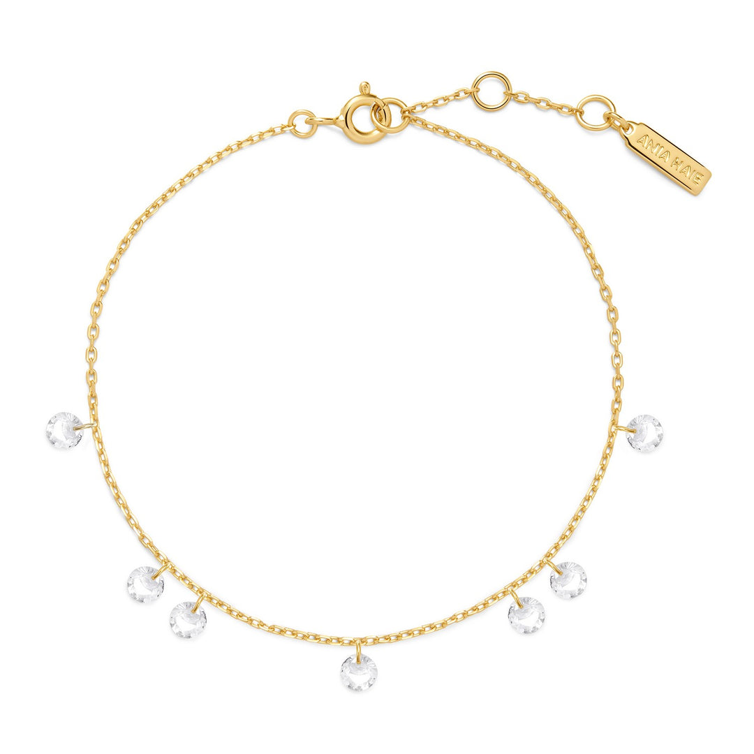 Gold bracelet with clear gemstones on a white background