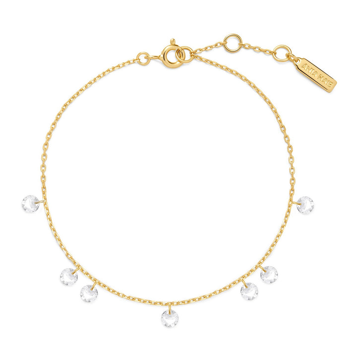 Gold bracelet with clear gemstones on a white background