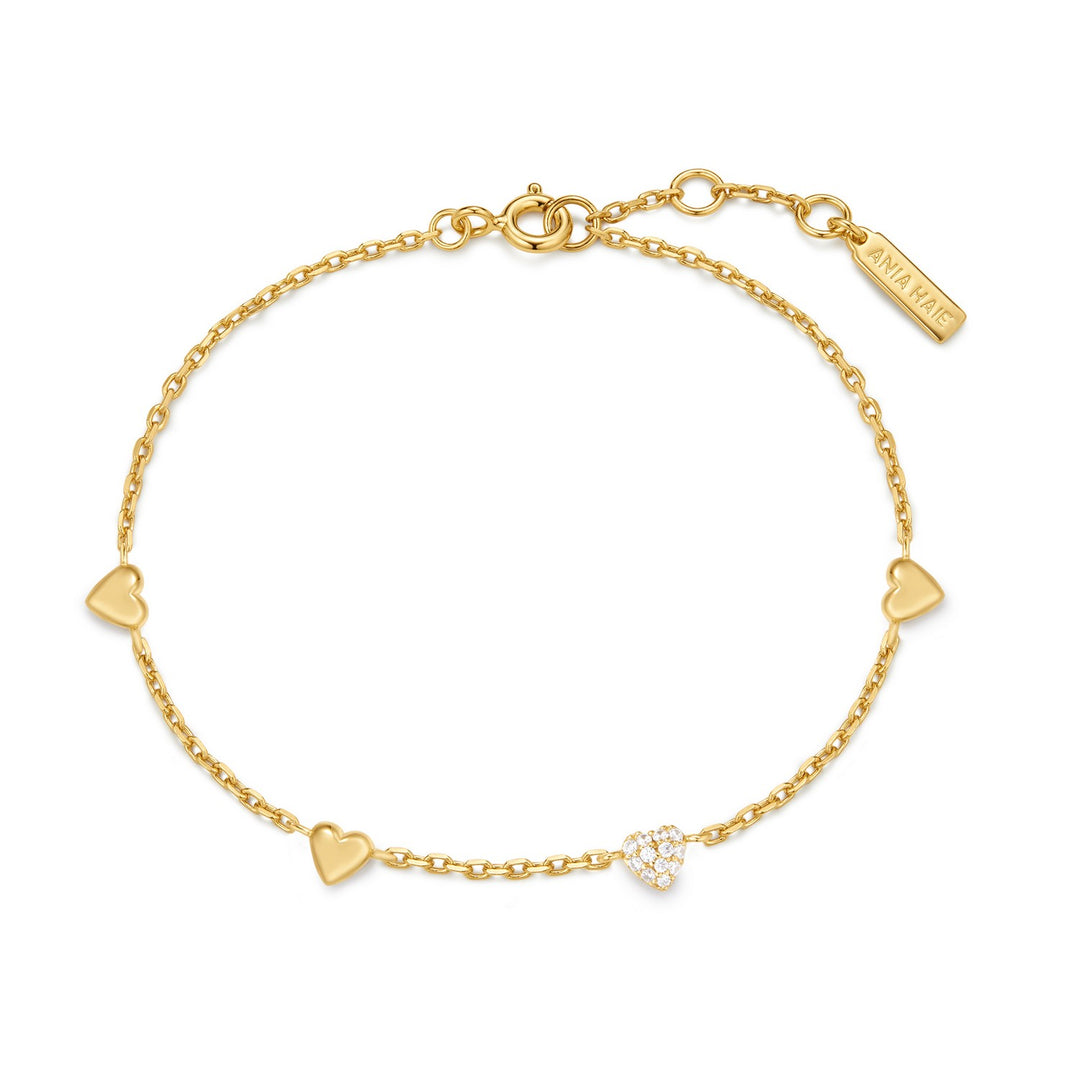 Gold bracelet with heart-shaped charms on a white background