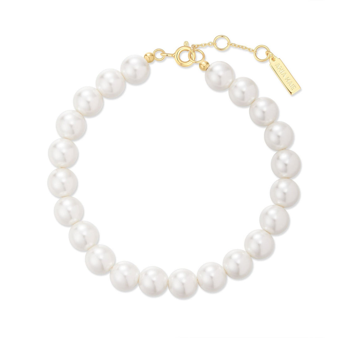 Pearl bracelet with gold clasp on a white background