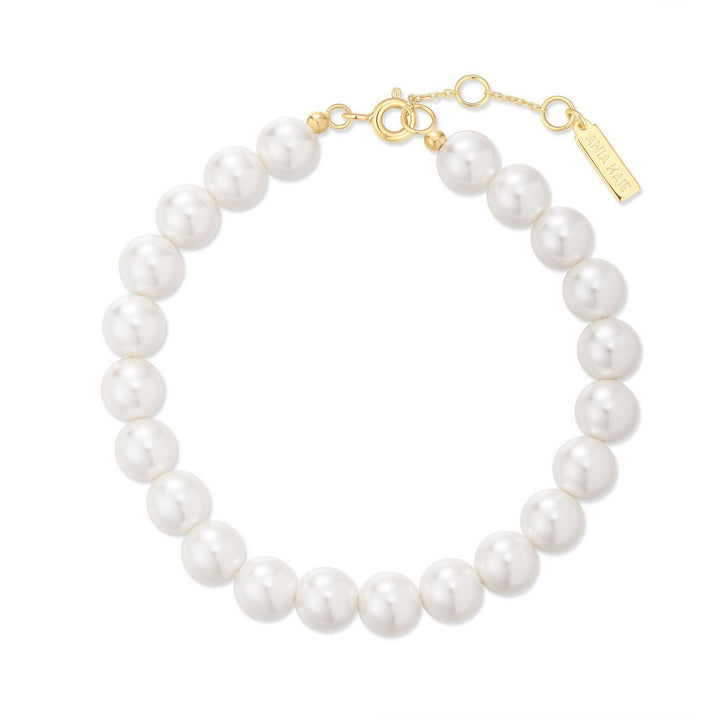 Pearl bracelet with gold clasp on a white background