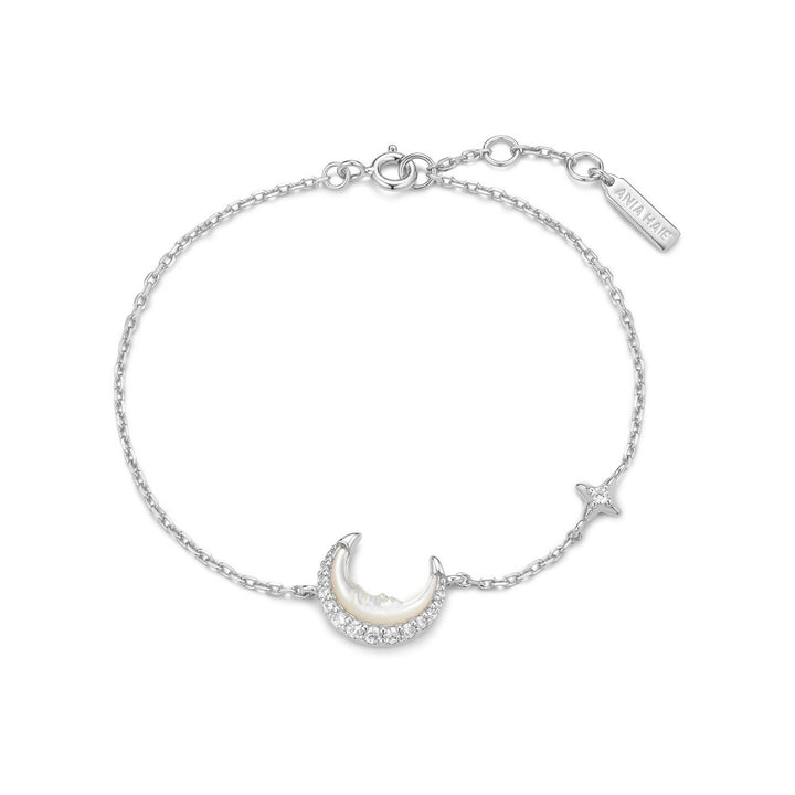 Silver bracelet with moon and star charms on a white background