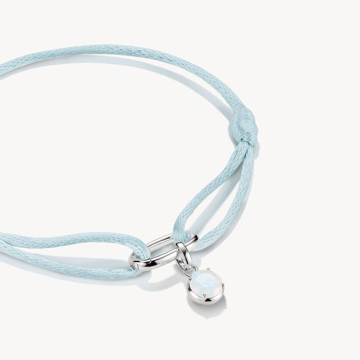 Light blue cord bracelet with a silver clasp and pendant on a white background
