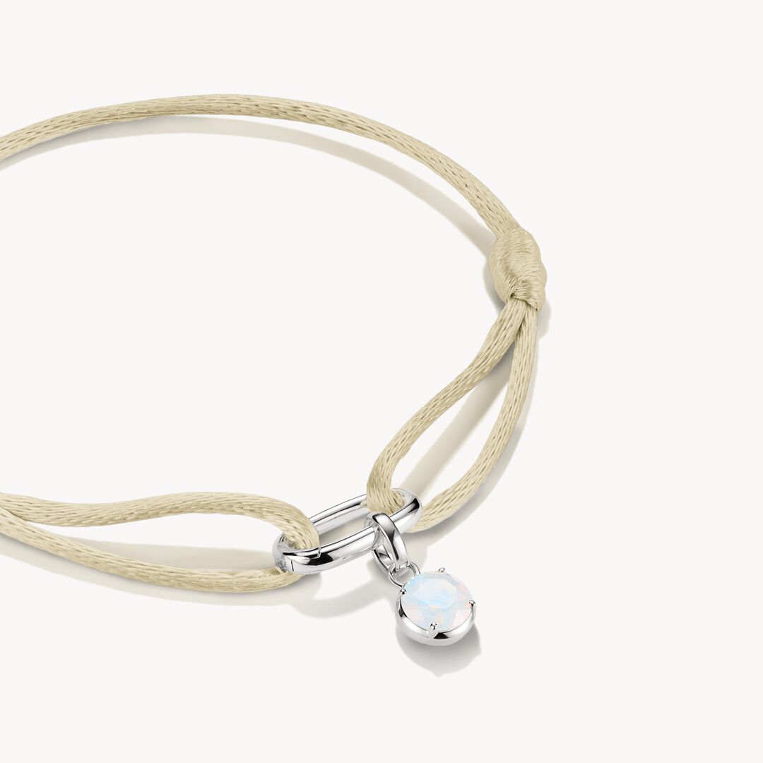 Beige cord bracelet with a silver clasp and opal pendant on a white background
