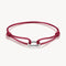 Red bracelet with a silver clasp on a white background