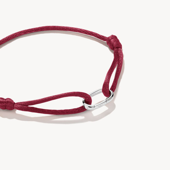 Red bracelet with a silver clasp on a white background