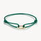 Green bracelet with a gold clasp on a white background