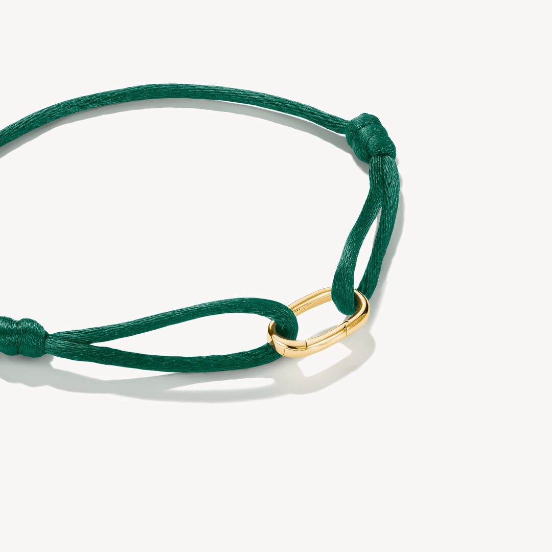 Green bracelet with a gold clasp on a white background