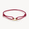 Red bracelet with a gold clasp on a white background