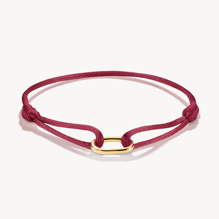 Red bracelet with a gold clasp on a white background