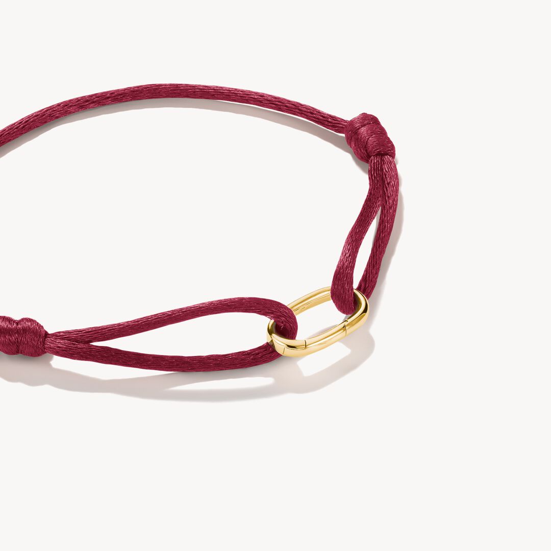 Red bracelet with a gold clasp on a white background