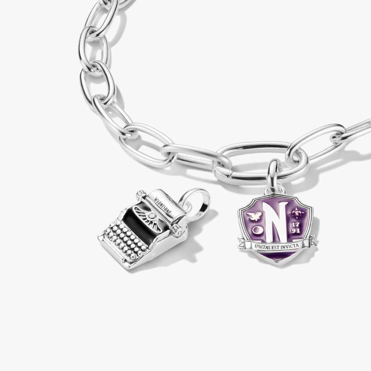 Silver bracelet with two charms on a white background