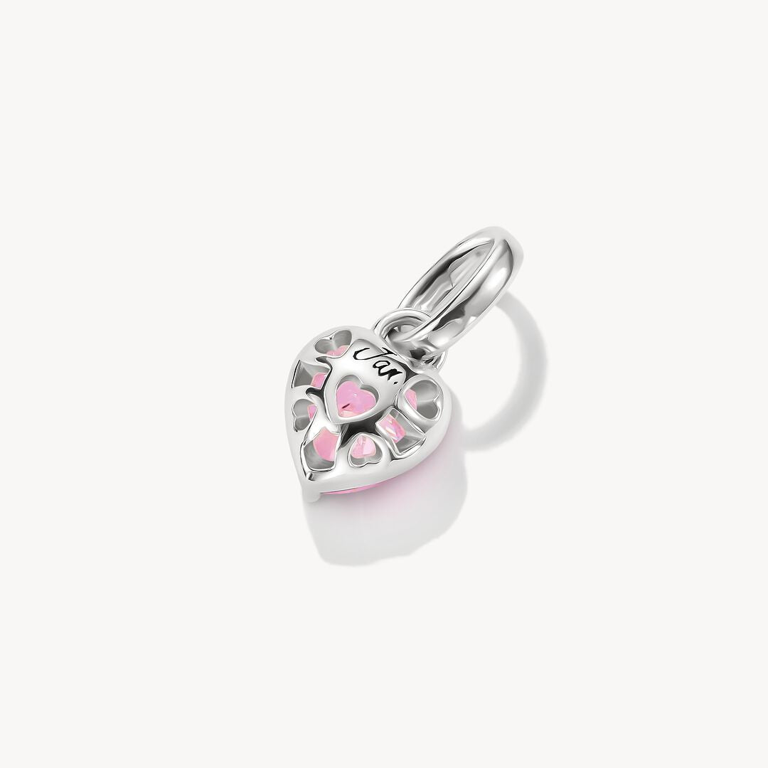 Heart-shaped pendant with a pink gemstone on a white background