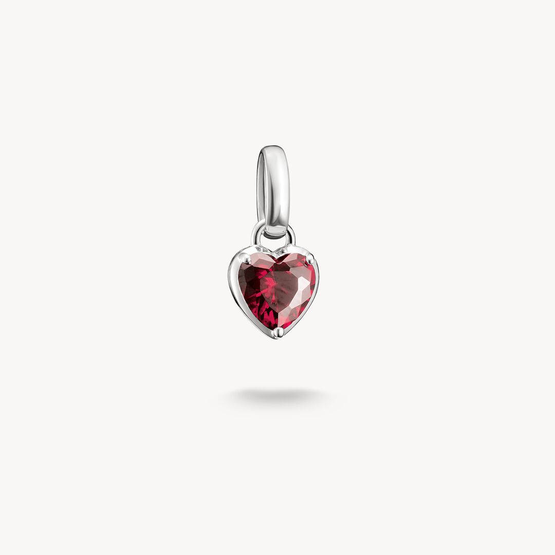 Heart-shaped pendant with a red gemstone on a white background