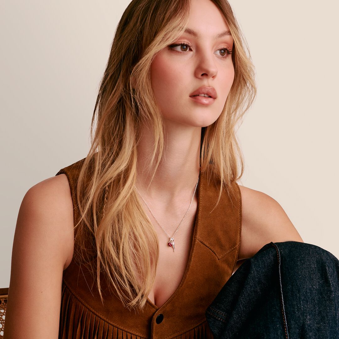 Woman wearing a brown suede vest with a plain background