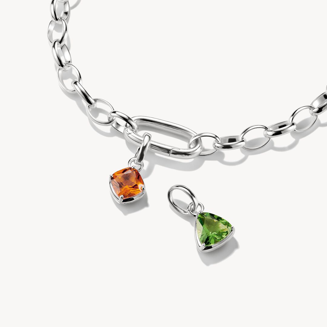 Silver bracelet with two charm pendants, one orange and one green, on a white background.