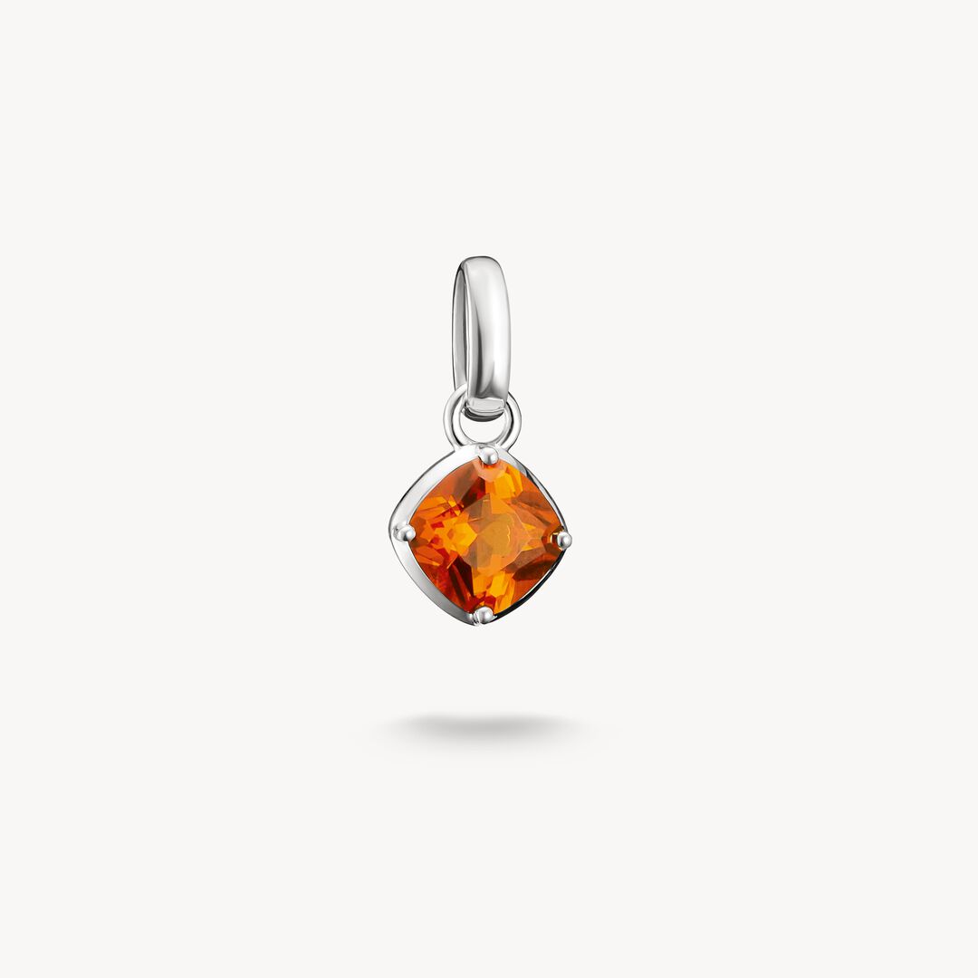 Silver pendant with a orange gemstone on a white background