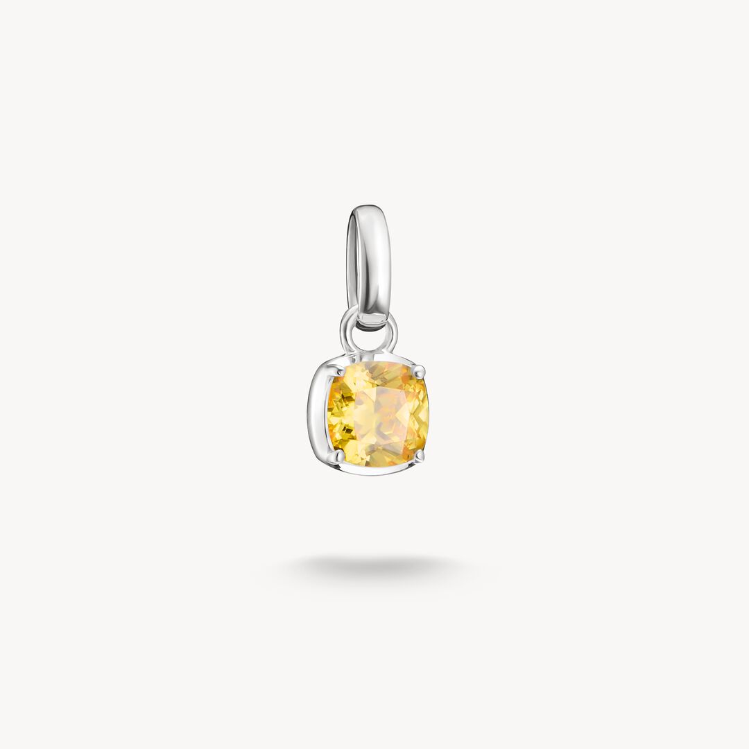 Silver pendant with a yellow gemstone on a white background