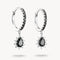 Pair of hoop earrings with black teardrop gemstones on a white background