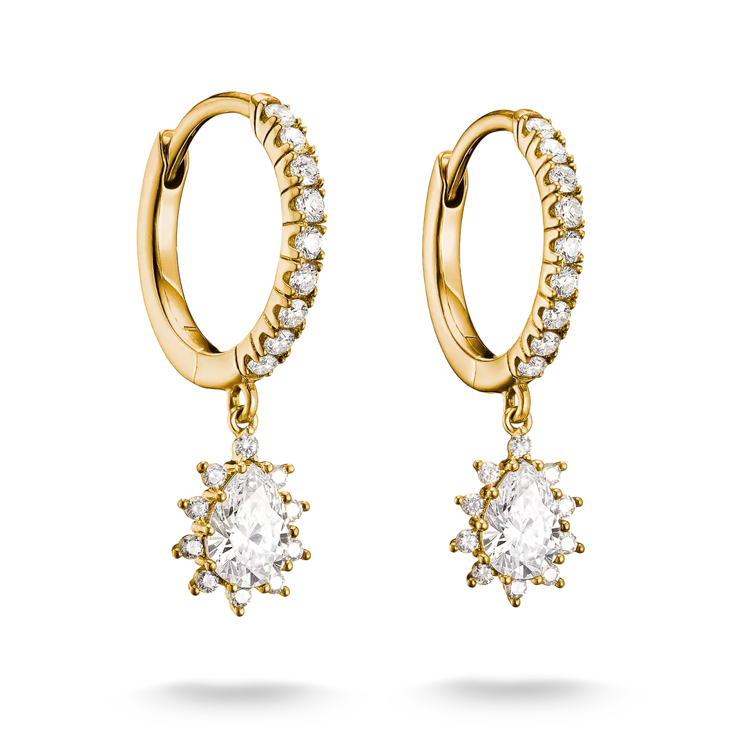 A pair of gold huggie hoop earrings with small clear stones along the front and a dangling starburst cluster featuring a large oval clear center stone surrounded by smaller clear stones, shown on a white background.