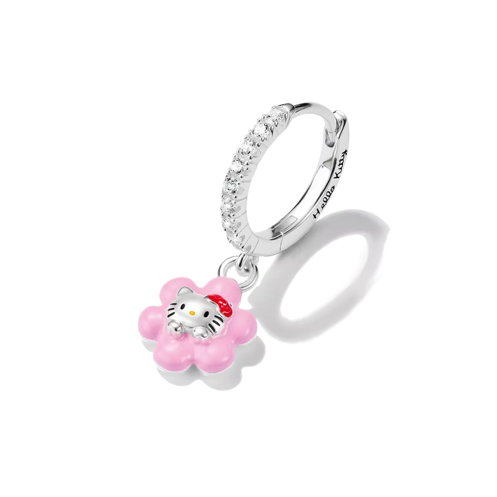 A silver huggie hoop earring adorned with clear crystals and a dangling pink flower charm featuring Hello Kitty in the center, shown on a white background with a soft shadow.