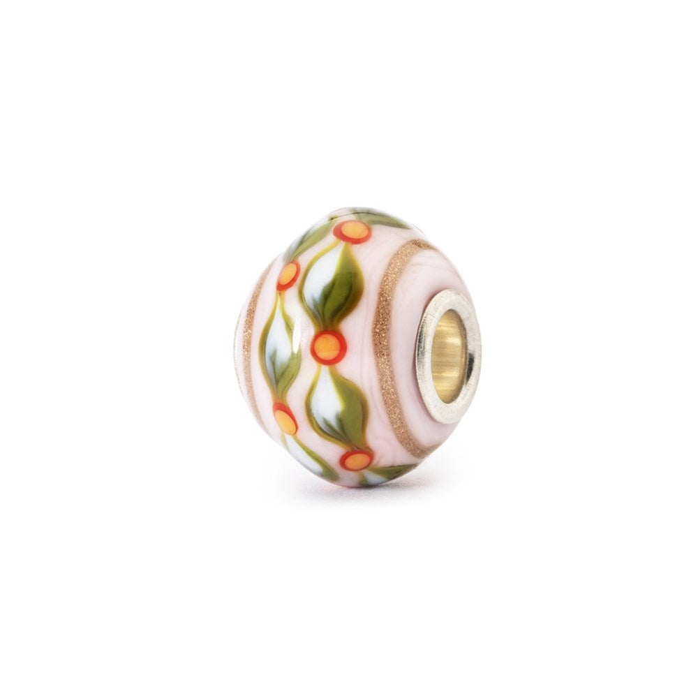 Decorative bead with floral pattern and gold accent on a white background