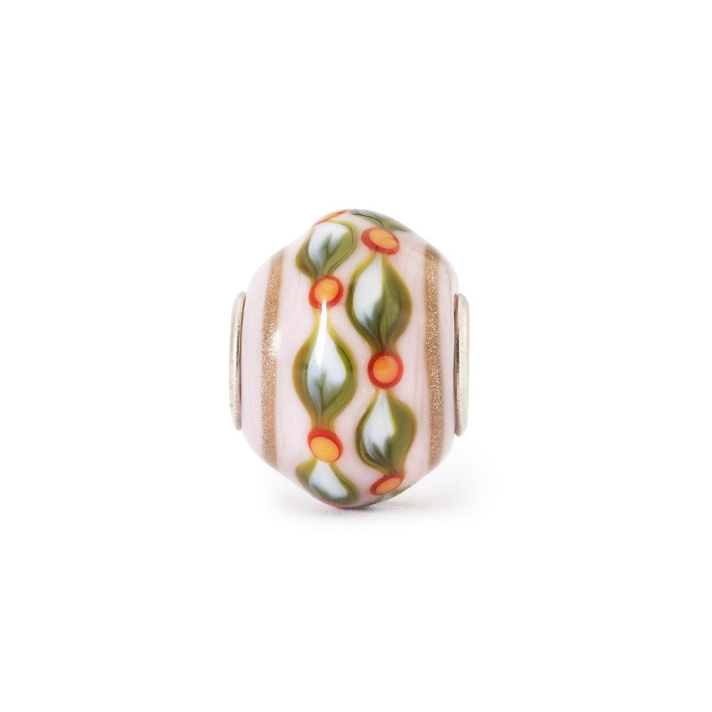 Decorative bead with floral pattern and gold accent on a white background