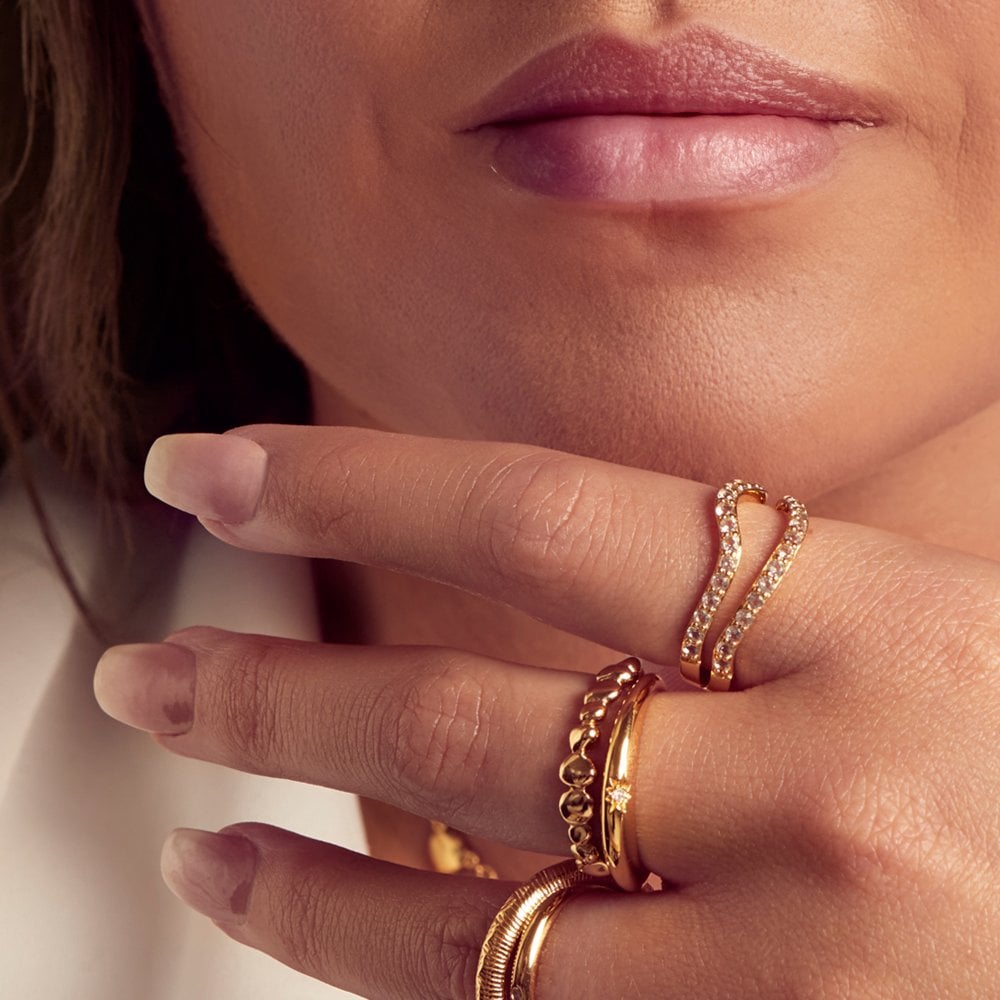Close-up of a hand wearing gold rings 