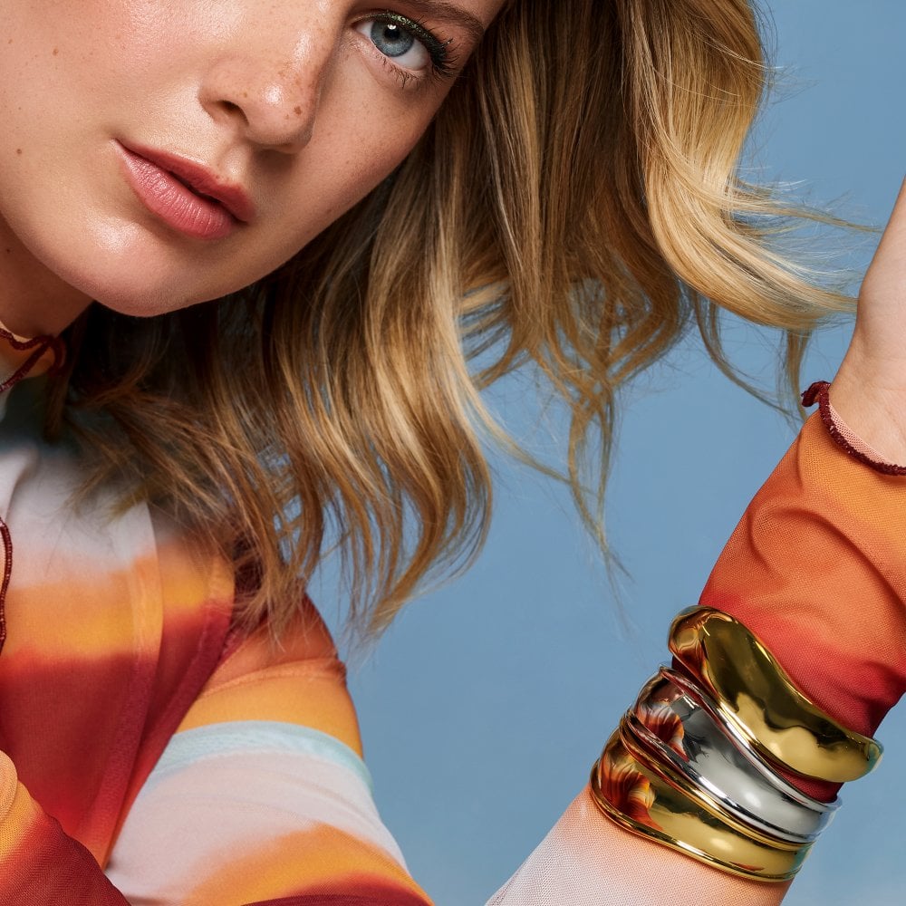 Woman wearing colorful clothing and multiple bracelets 
