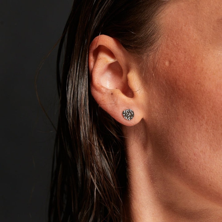 Close-up of an ear wearing a small stud earring 