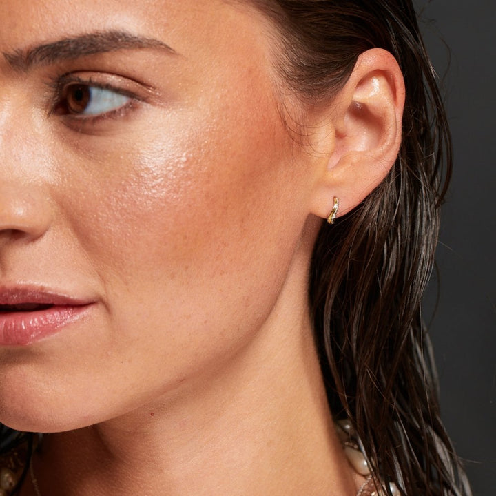 Close-up of a woman's face with a focus on her ear and earring.