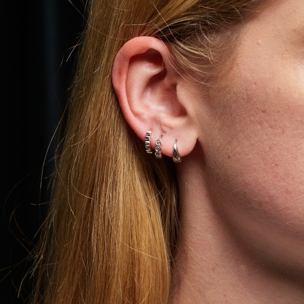 Close-up of an ear wearing hoop earrings 