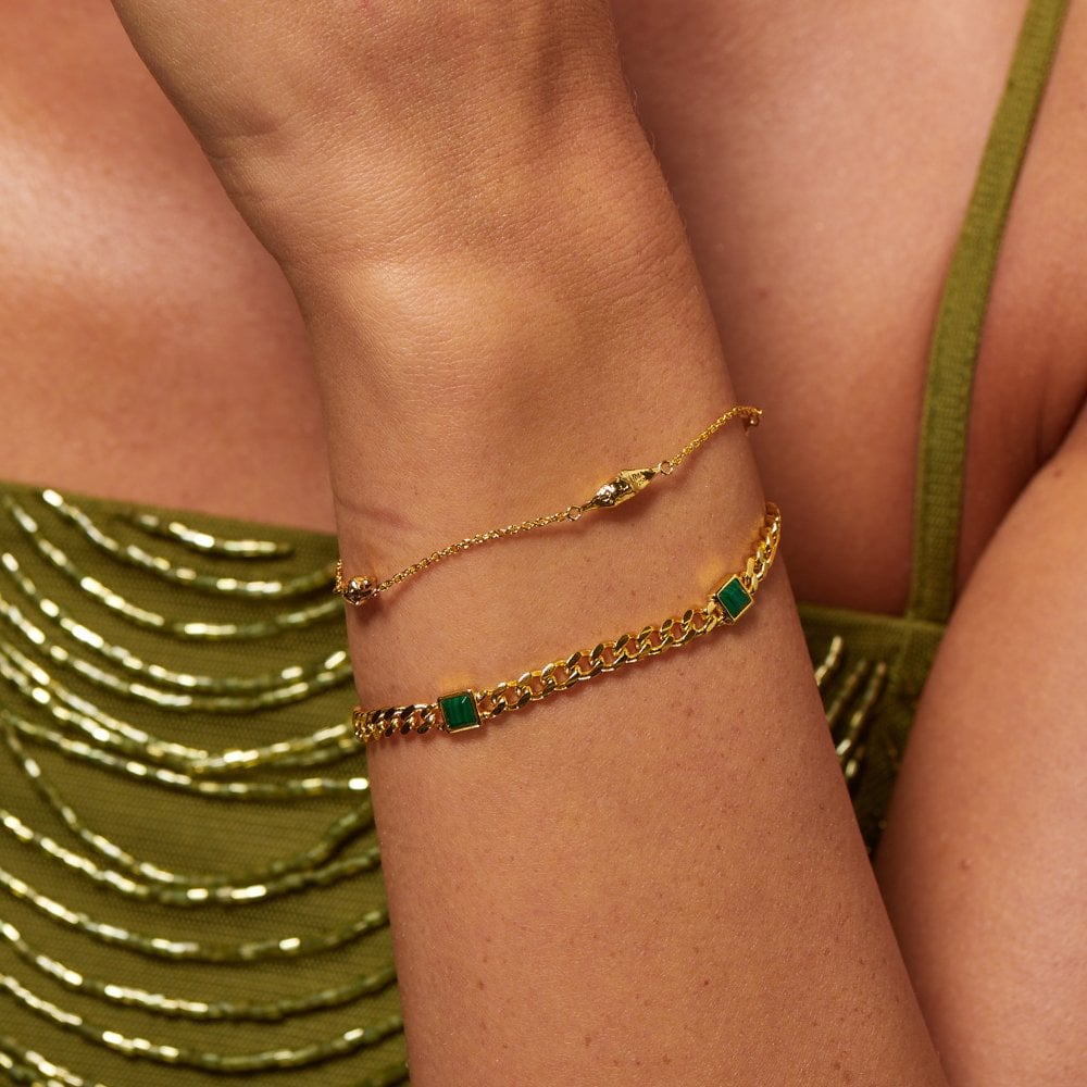 Gold bracelet with green stones on a wrist 