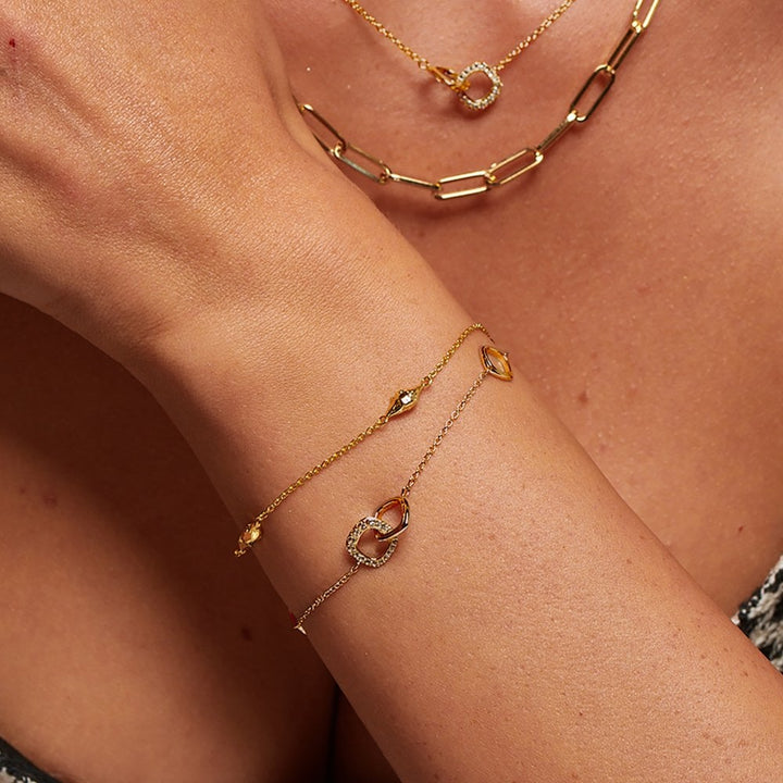 Gold bracelet and necklace set on a person's wrist and neck