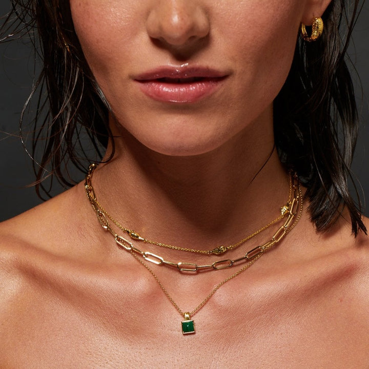 Close-up of a woman wearing gold necklaces and earrings 