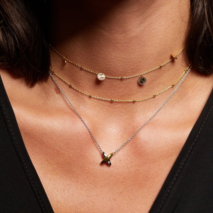 Necklace with a pendant on a person wearing a black top