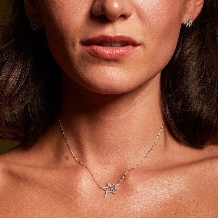 Close-up of a woman wearing a star-shaped necklace and earrings.