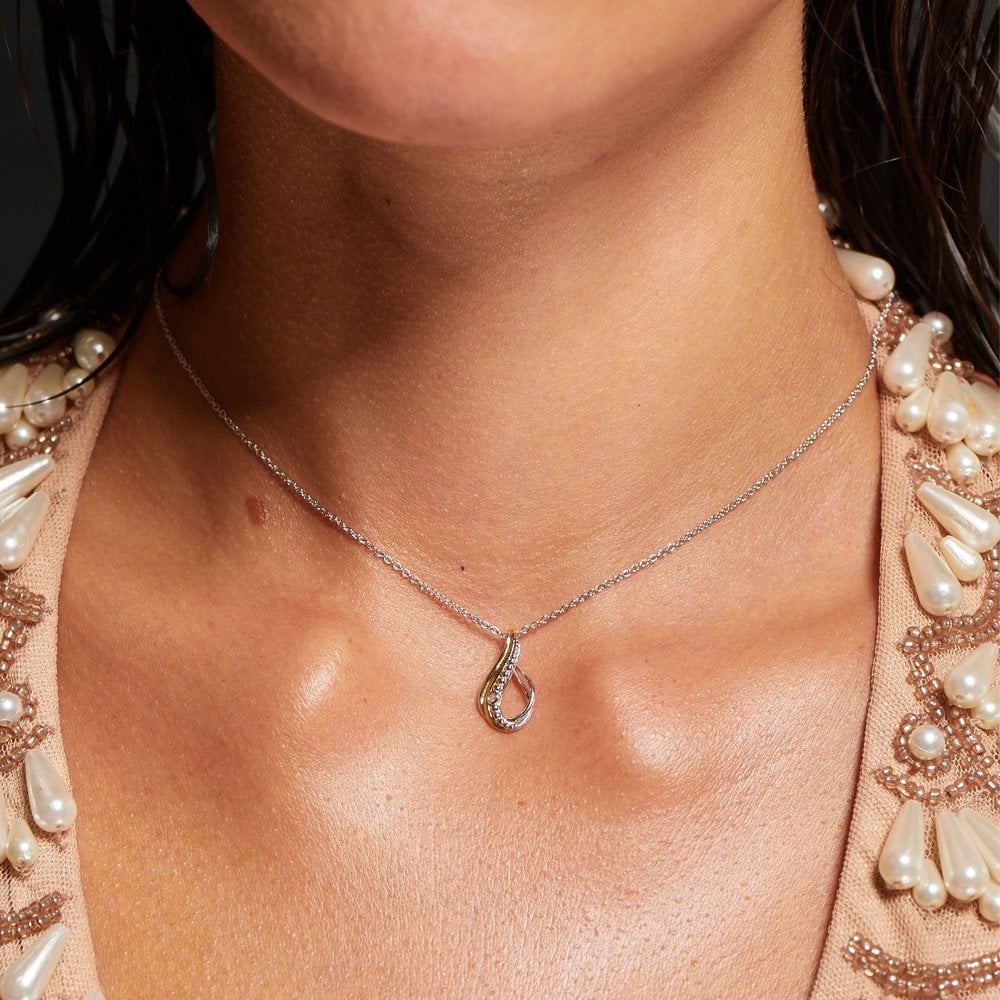 Necklace with a pendant worn by a person, with a focus on the jewelry.