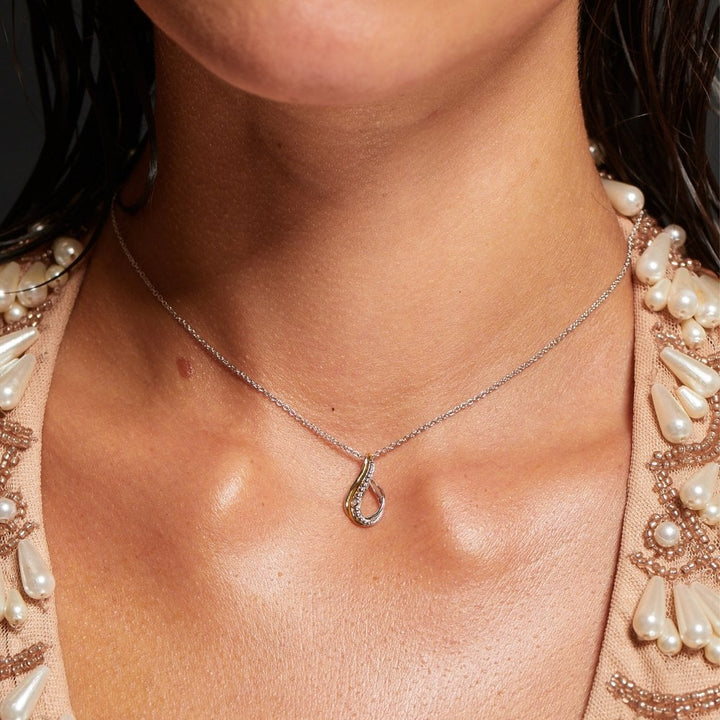 Necklace with a pendant worn by a person, with a focus on the jewelry.