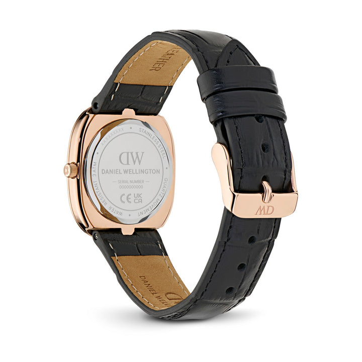 Daniel Wellington watch shown from the back, featuring a rose gold case and a black alligator leather strap with tan stitching and a matching rose gold buckle.