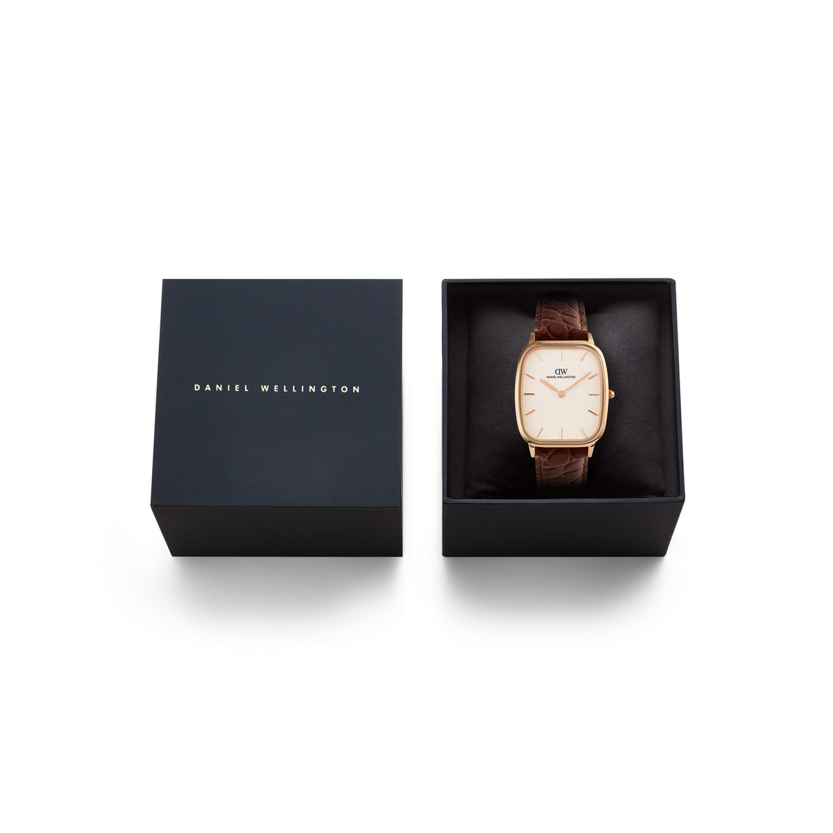 Daniel Wellington watch with a rose gold case, cream dial, and brown leather strap, shown next to its black presentation box on a white background.