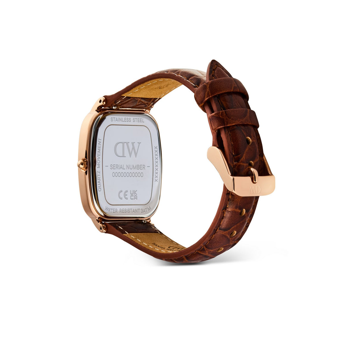 A close-up shot of a watch's rose gold case and brown leather strap underside, showing the brand logo 'DW' and serial number on the stainless steel backplate, set against a plain white background.