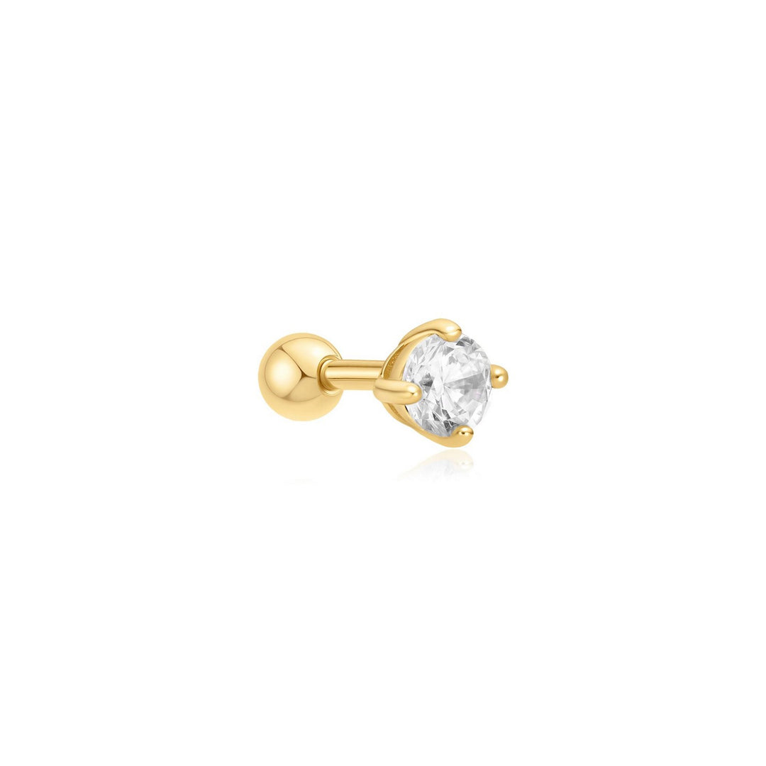 Gold earring with a clear gemstone on a white background