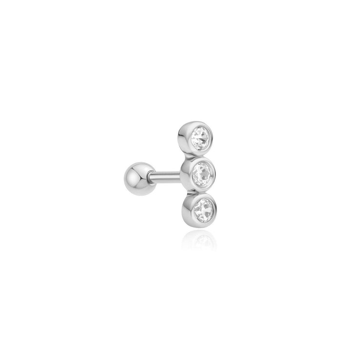 Silver earring with three clear gemstones on a white background