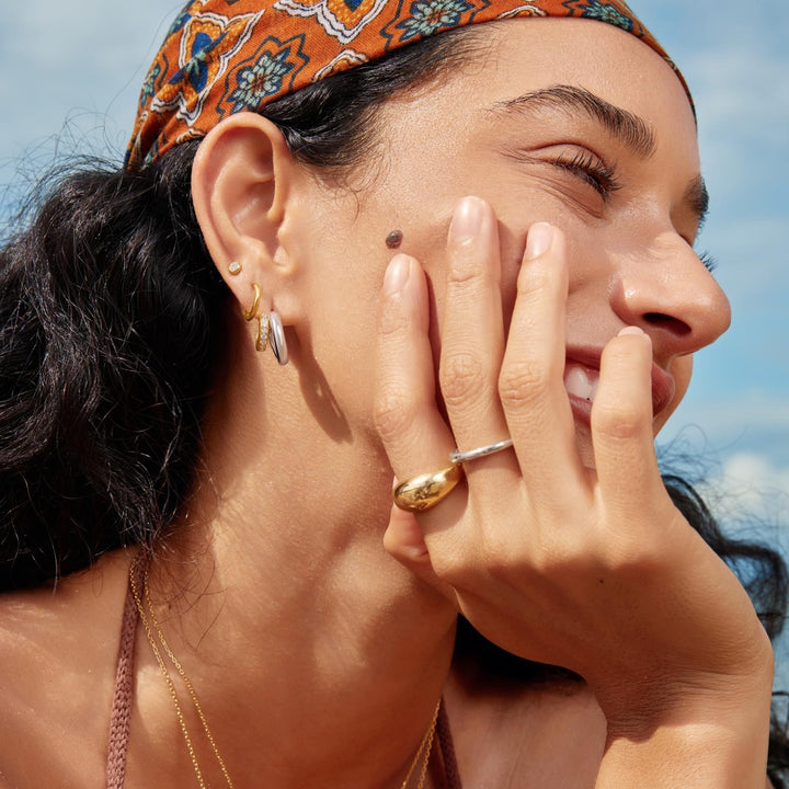 Woman with a headscarf and jewelry outdoors