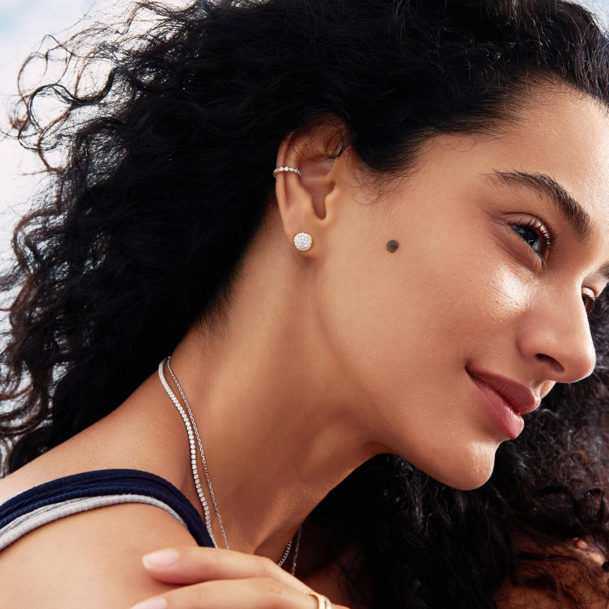 Close-up of a woman wearing earrings and a necklace with a blurred background