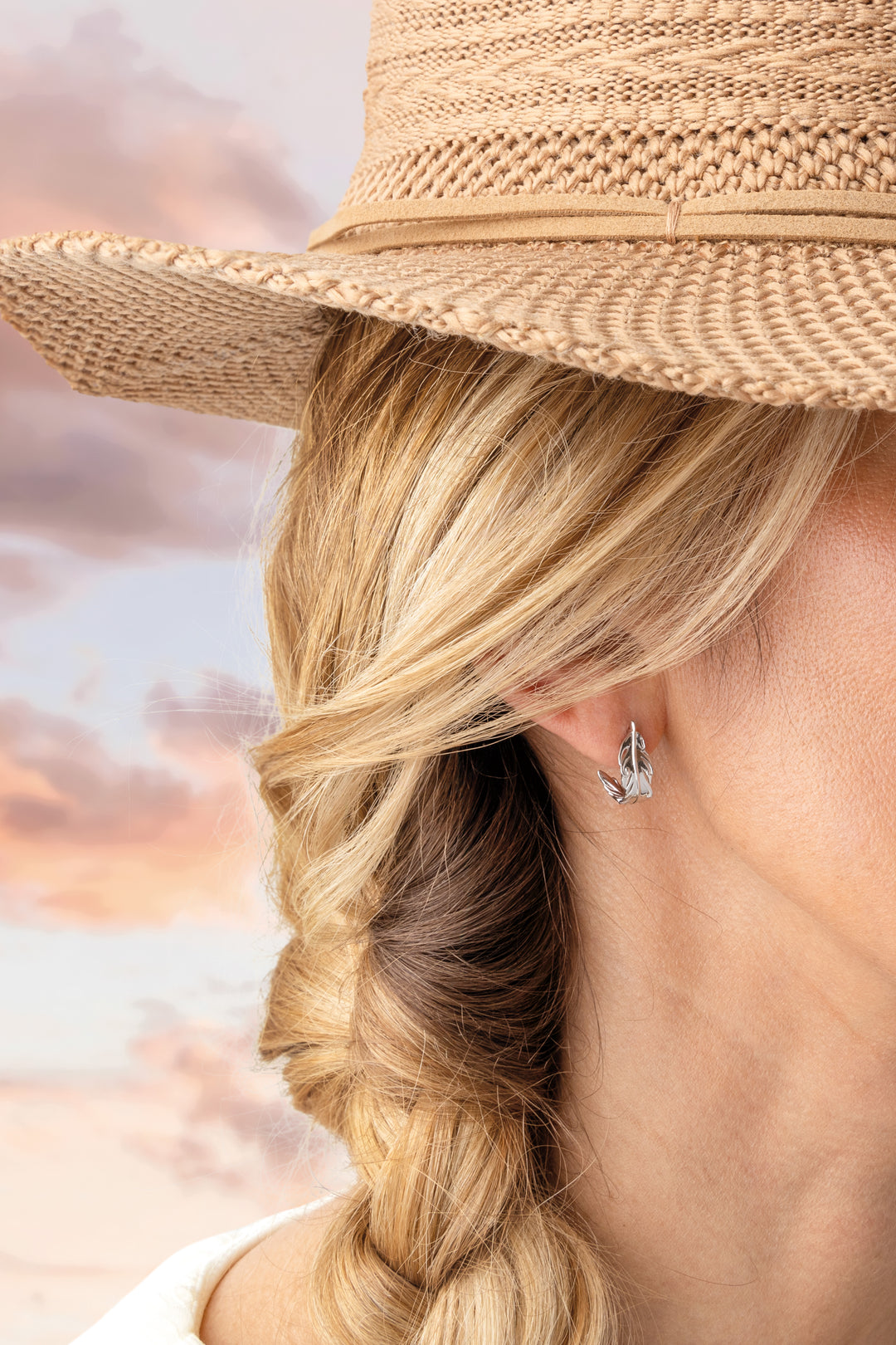 Person wearing a straw hat with a blurred beach background