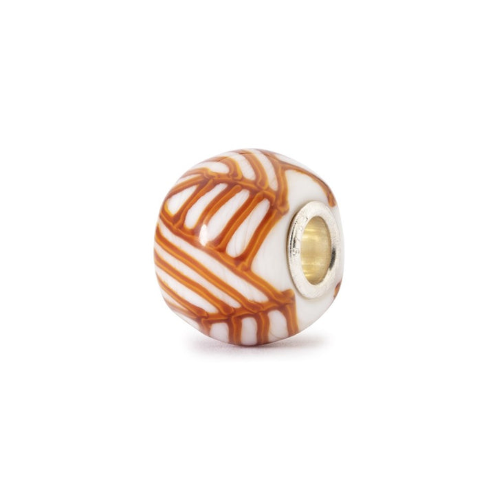 Decorative bead with orange and white pattern on a white background