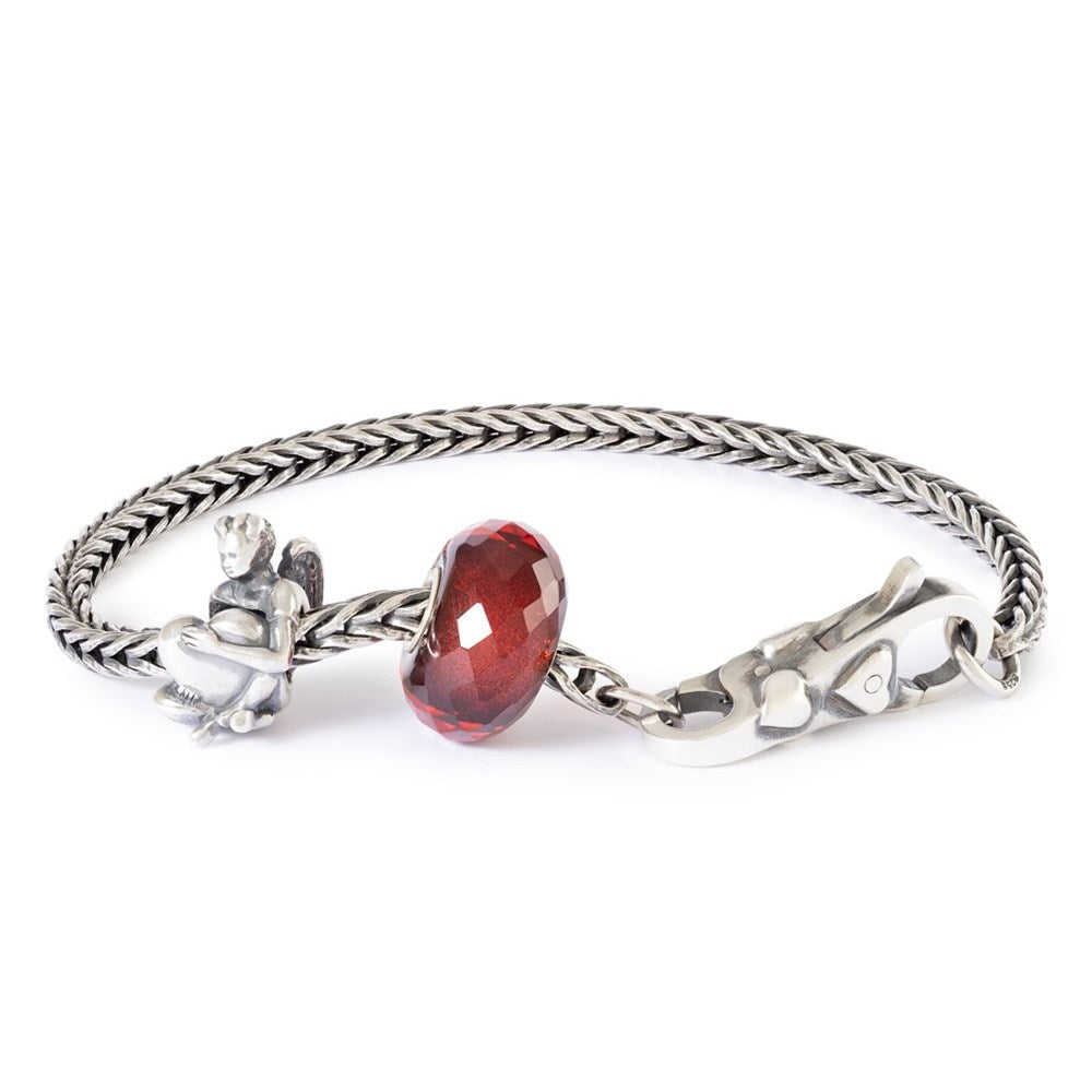 Silver bracelet with a red gemstone on a white background