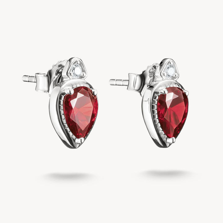 Pair of silver earrings with red gemstones on a white background